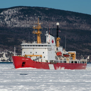 Older man looks out of a bus window + Canadian icebreaker