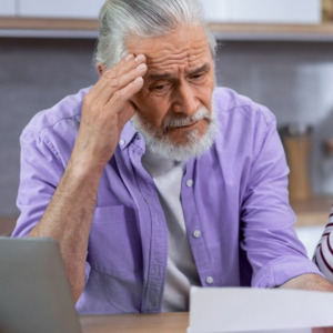 Older man and woman looking at receipts and appear to be stressed