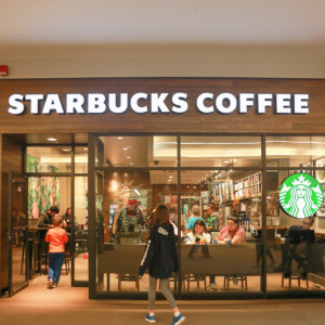 New Jersey Starbucks Coffee store front + Young blond woman drinking from Starbucks disposable cup