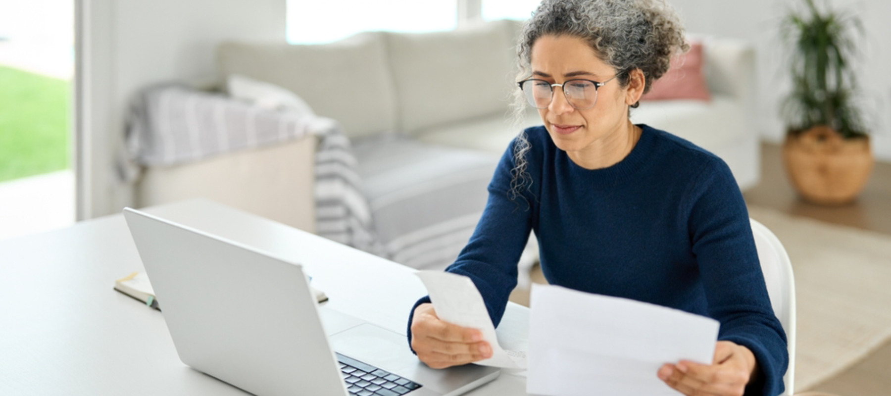 Mature lady calculating tax refund using laptop