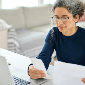 Mature lady calculating tax refund using laptop
