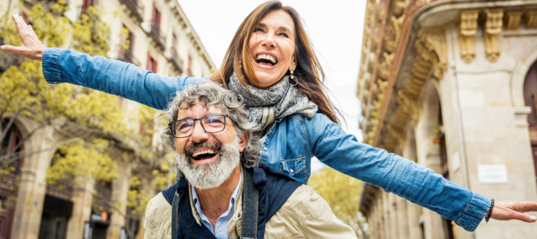 Happy senior couple having fun walking on city street