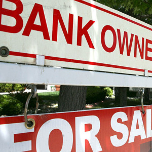 A bank owned for sale sign is posted in front of a foreclosed home May 7, 2009