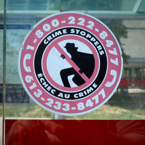 Crime Stoppers sign, police yellow tape