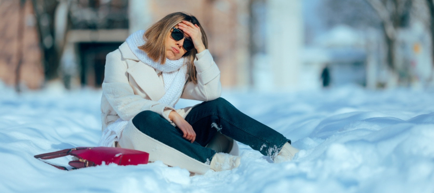 Frustrated woman sits down after shovelling snow
