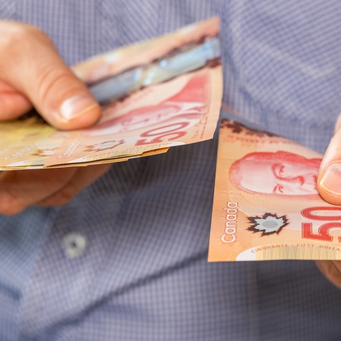 Man paying with Canadian $50 bills. Cash in hand.