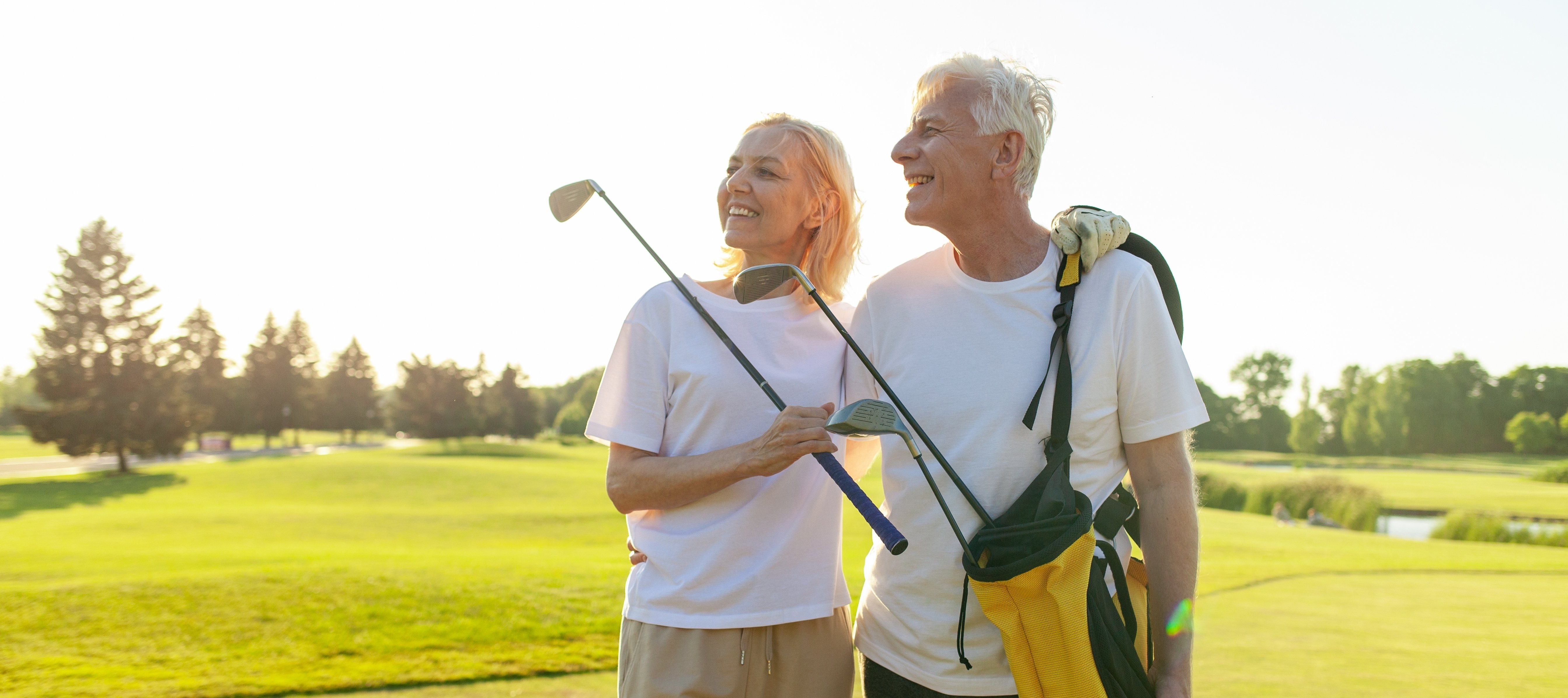 Older wealthy couple standing together on the golf course
