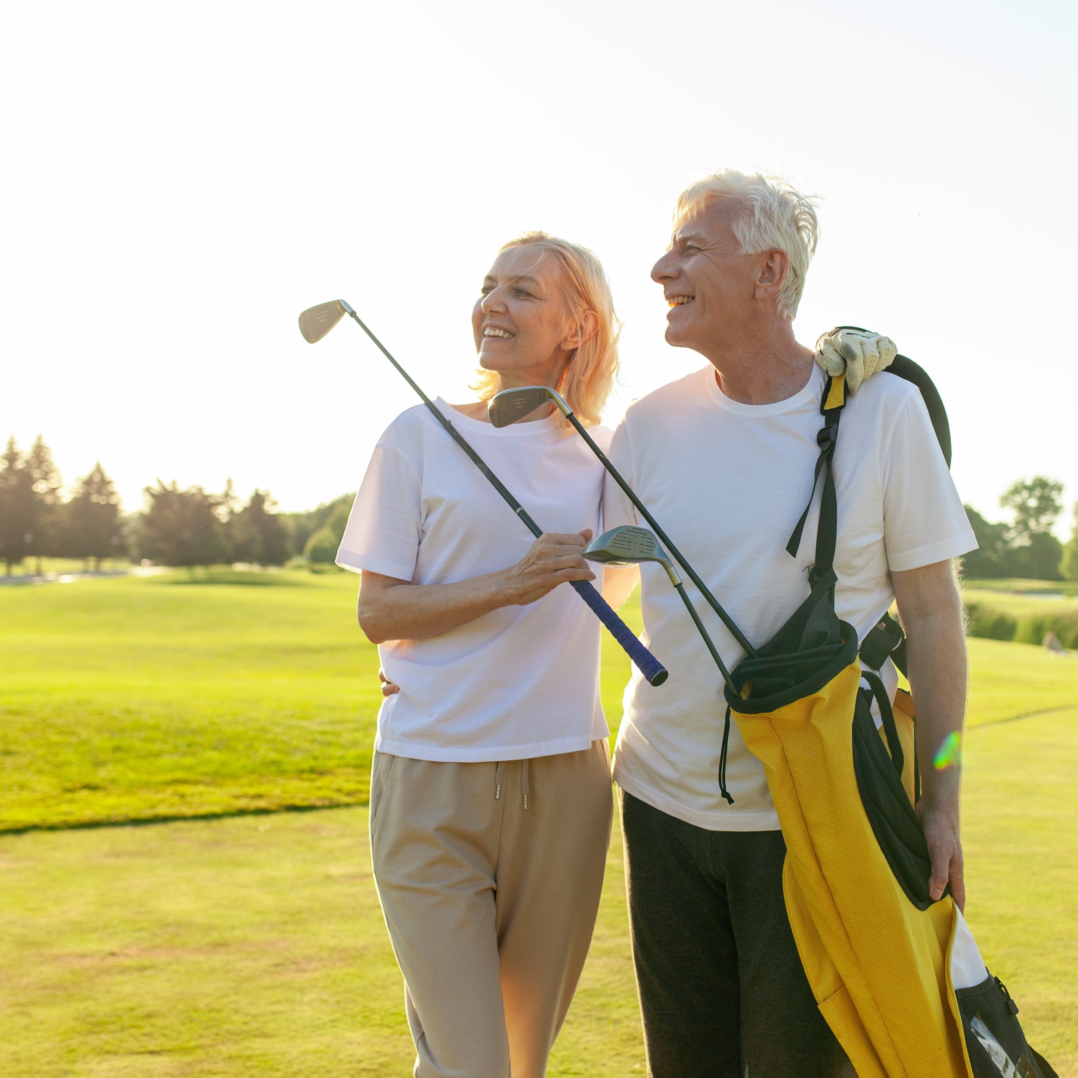 Older wealthy couple standing together on the golf course