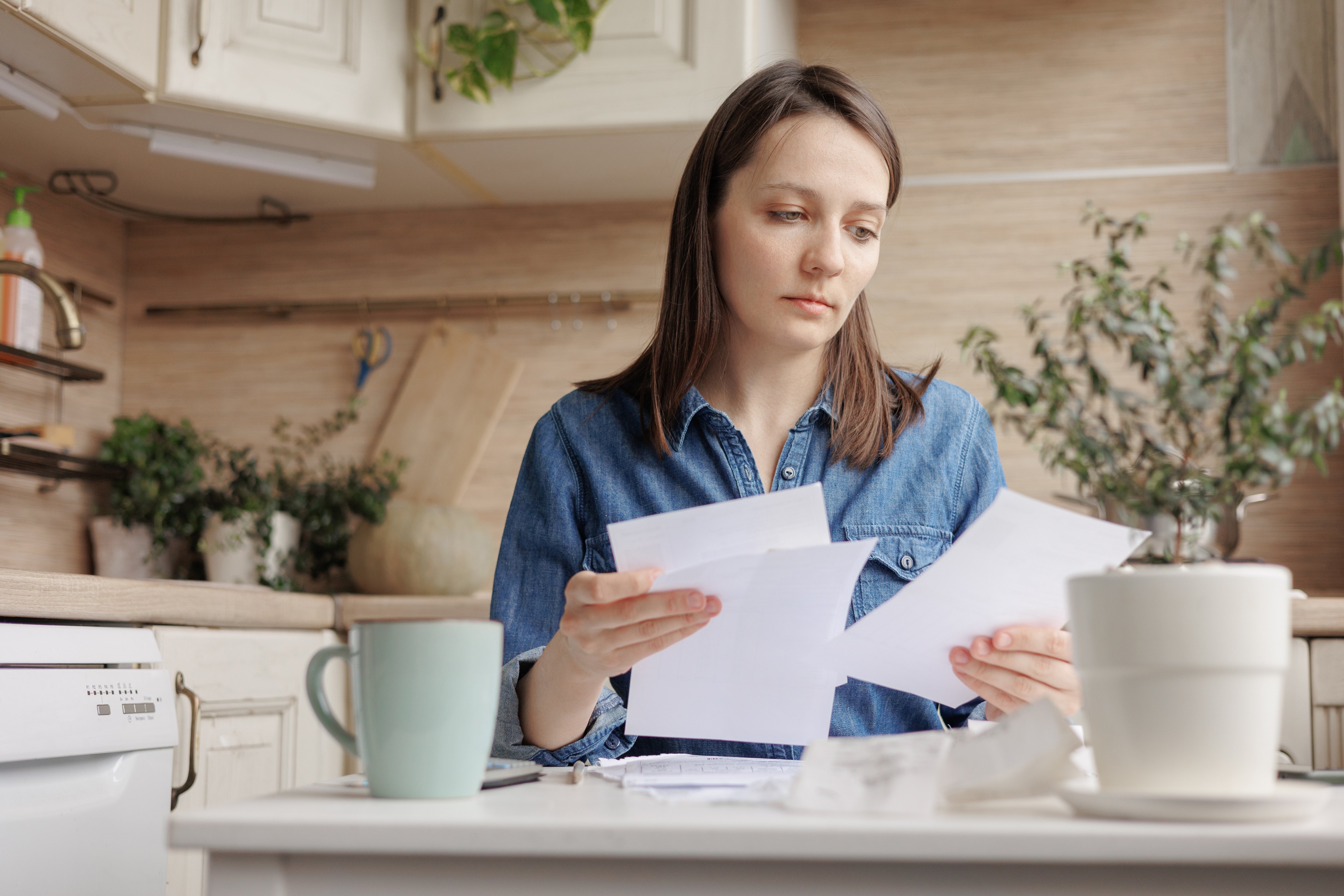 Woman looking unhappy at letter in her hand. 